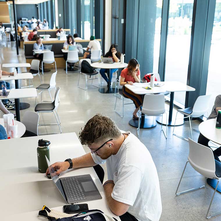 Student on a laptop in the food court.