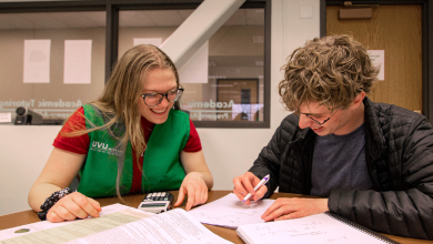 Math Lab tutor in green vest helping a student